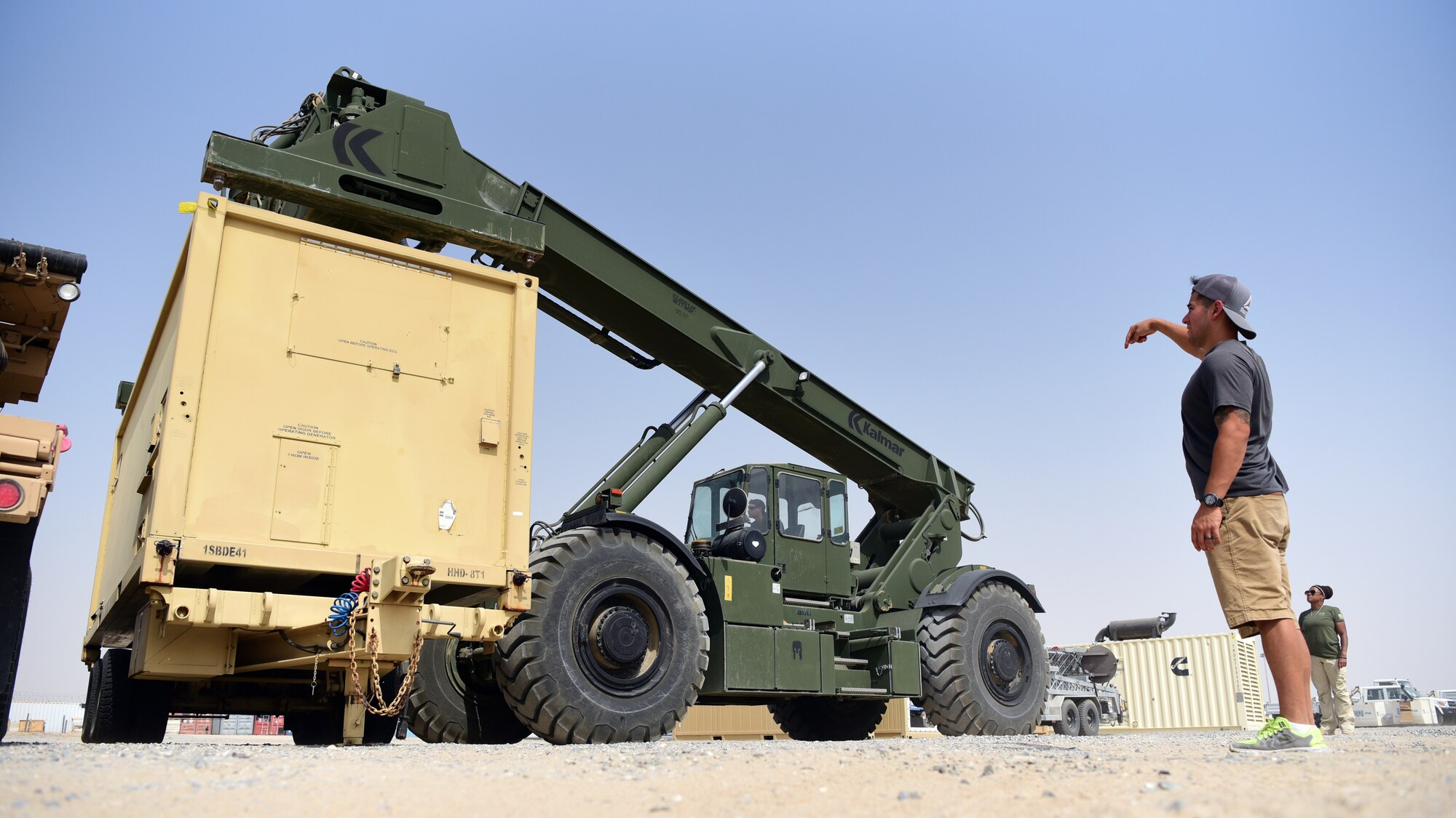 U.S. Army Staff Sgt. Abraham Ruiz, Joint Special Operations Forces Support Detachment – K motor transport operator, helps U.S. Army Sergeant William Poley, JSSD-K movements specialist, use Kalmar RT240 rough terrain container handler to lift equipment June 4, 2018, at an undisclosed location in Southwest Asia. (U.S. Air Force photo by Staff Sgt. Christopher Stoltz)