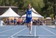 Female athlete crosses finish line with arms outstretched