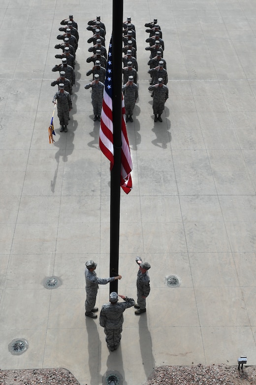 Members of the 4th Space Operations Squadron lower the flag during a retreat ceremony at Schriever Air Force Base, Colorado, June 5, 2018. The ceremony was conducted to commemorate the official day Falcon Air Force Base was named Schriever AFB. (U.S. Air Force photo by Dennis Rogers)