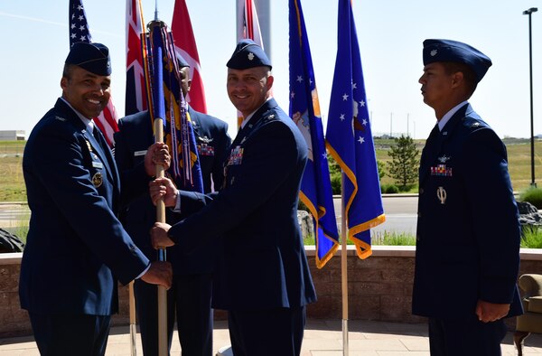 Lt. Col. Ethan Mattox, center, 11th Space Warning Squadron outgoing commander, relinquishes the guidon to Col. Lorenzo Bradley, left, 460th Operation Group commander, June 12, 2018, on Buckley Air Force Base, Colorado. The 11 SWS supports the base mission of space-based missile warning alongside the 2nd and 8th Space Warning Squadrons. (U.S. Air Force photo by Senior Airman AJ Duprey)