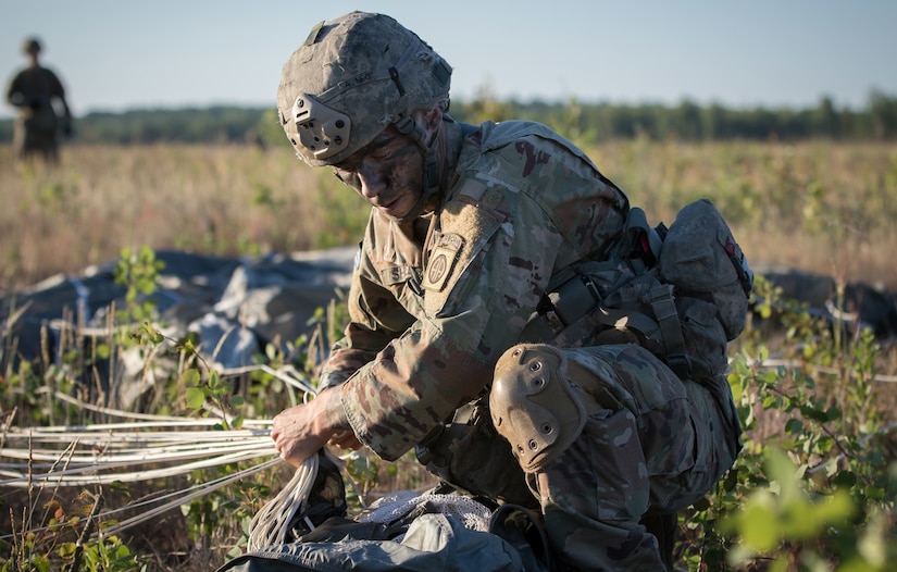 Army Spc. Sean Shelts, with the 1st Battalion, 508th Infantry Regiment, packs his parachute and collects his gear after jumping from an aircraft near Rukla, Lithuania, as part of exercise Swift Response 18, June 9, 2018. Army photo by Spc. Andrew McNeil