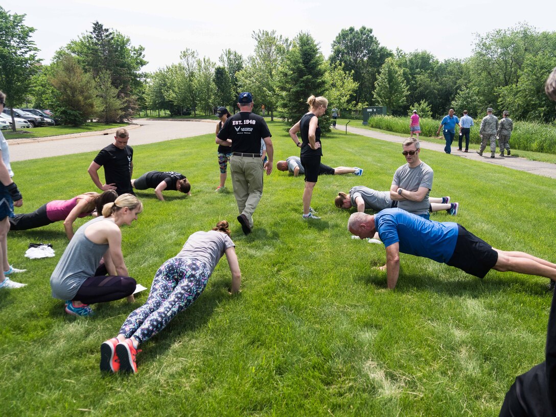 Thomson Reuters employees perform pushups. (Air Force Photo/Paul Zadach)