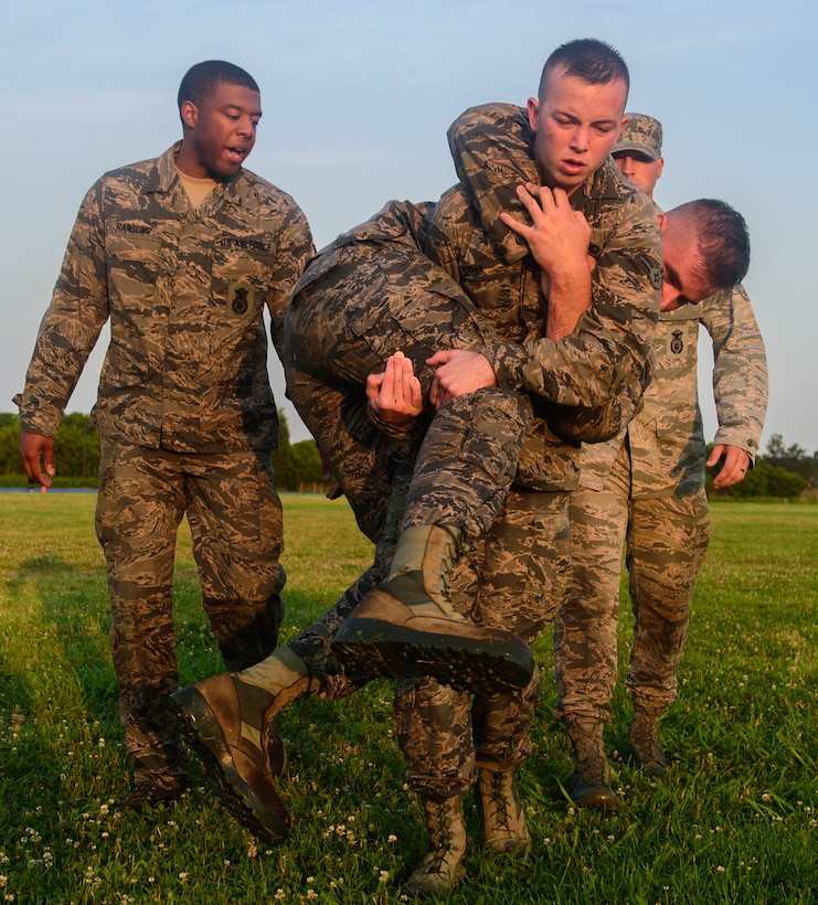 U.S. Air Force Airman 1st Class Nicholas Smoak, 633rd Security Forces Squadron entry controller, fireman carries another candidate during an emergency services team tryouts at Joint Base Langley-Eustis, Virginia, June 8, 2018. During the fitness obstacle course, the five first responders performed a low crawl, high crawl, ammunition can carry and a fireman carry. (U.S. Air Force photo by Senior Airman Derek Seifert)