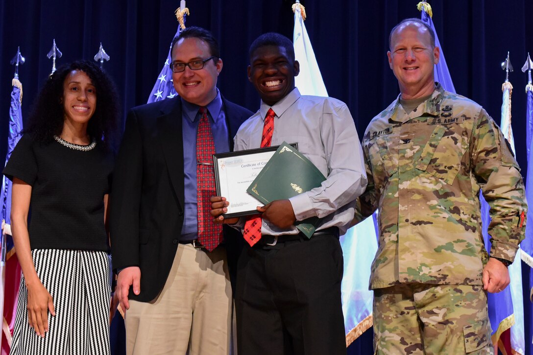 Fort Eustis leaders and liaisons pose with a Project SEARCH graduate in Fort Eustis’ Wylie Theater at Joint Base Langley-Eustis, Virginia, June 7, 2018. JBLE partnered with Virginia Commonwealth University to aid military dependents in the workforce. (U.S. Air Force photo by Airman 1st Class Monica Royba