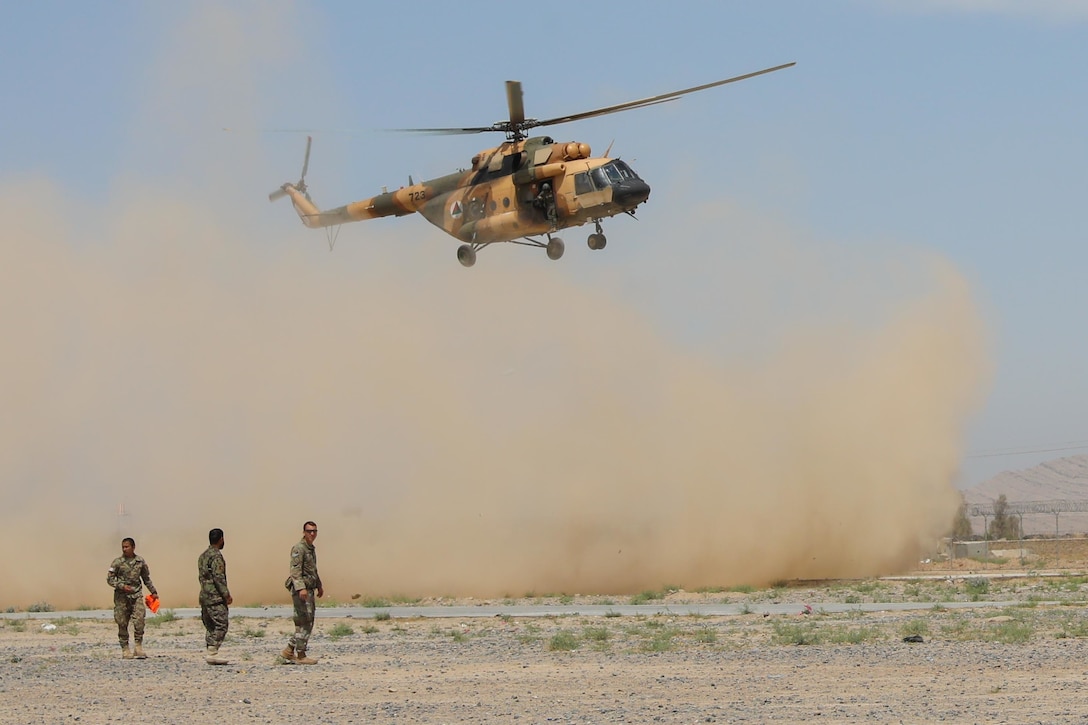 Army Sgt. Christian Ladd, a combat medic assigned to 2nd Battalion, 1st Security Force Assistance Brigade, and two Afghan soldiers wait for an Mi-17 helicopter to land, May 8, 2018, during a medical evacuation exercise hosted by soldiers from the 2nd Battalion, 1st Security Forces Assistance Brigade at Regional Military Training Center-Kandahar in Kandahar, Afghanistan. Army photo by Staff Sgt. Neysa Canfield