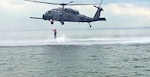 A member of the New York National Guard's 24th Weapons of Mass Destruction Civil Support Team exists a hovering HH-60 Pave Hawk helicopter assigned to the 106th Rescue Wing during helocasting training off Fort Hamilton, Brooklyn in Gravesends Bay on June 6, 2018.