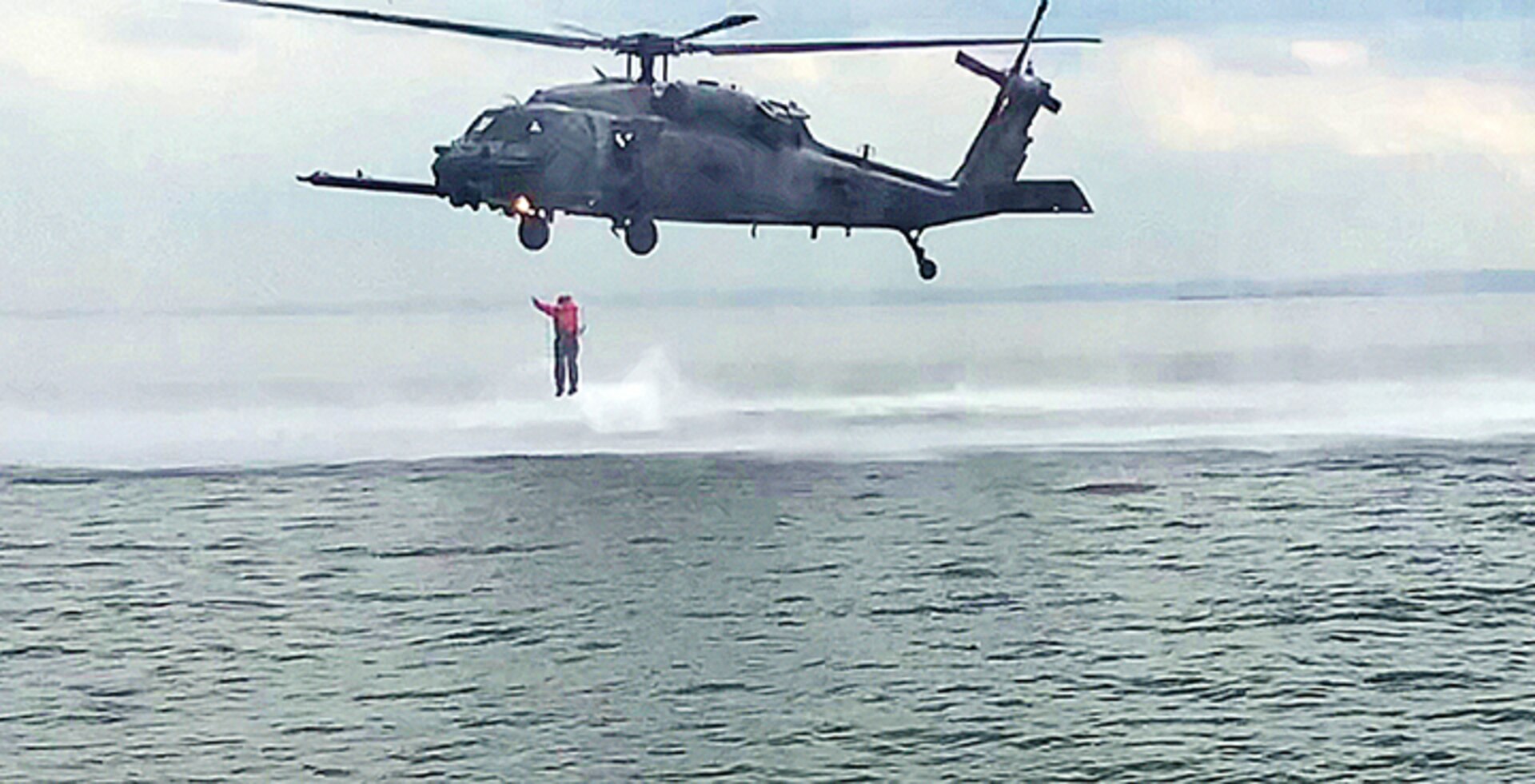 A member of the New York National Guard's 24th Weapons of Mass Destruction Civil Support Team exists a hovering HH-60 Pave Hawk helicopter assigned to the 106th Rescue Wing during helocasting training off Fort Hamilton, Brooklyn in Gravesends Bay on June 6, 2018.