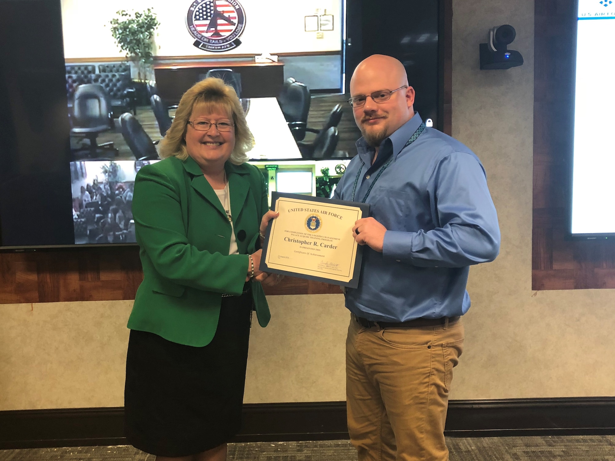 Christopher Carder, a Logistics Management PALACE Acquire intern assigned to the Air Force Life Cycle Management Center's Propulsion Directorate, receives a graduation certificate from Cynthia Abbott, Director of the AFLCMC Logistics Directorate. Carder successfully completed the two-year internship program. (Courtesy photo)