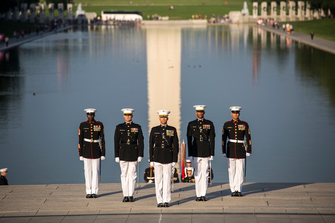 Marines with the Marine Barracks Washington D.C. parade marching staff stand at attention during the Sunset Parade at the Lincoln Memorial, Washington D.C., June 12, 2018. This year is the first year the Barracks Marines are hosting Tuesday Sunset Parades at the Lincoln Memorial. The guest of honor for the parade was Secretary of the Interior Ryan Zinke and the hosting official was Robert D. Hogue, counsel for the commandant of the Marine Corps. (Official U.S. Marine Corps photo by Sgt. Robert Knapp/Released)