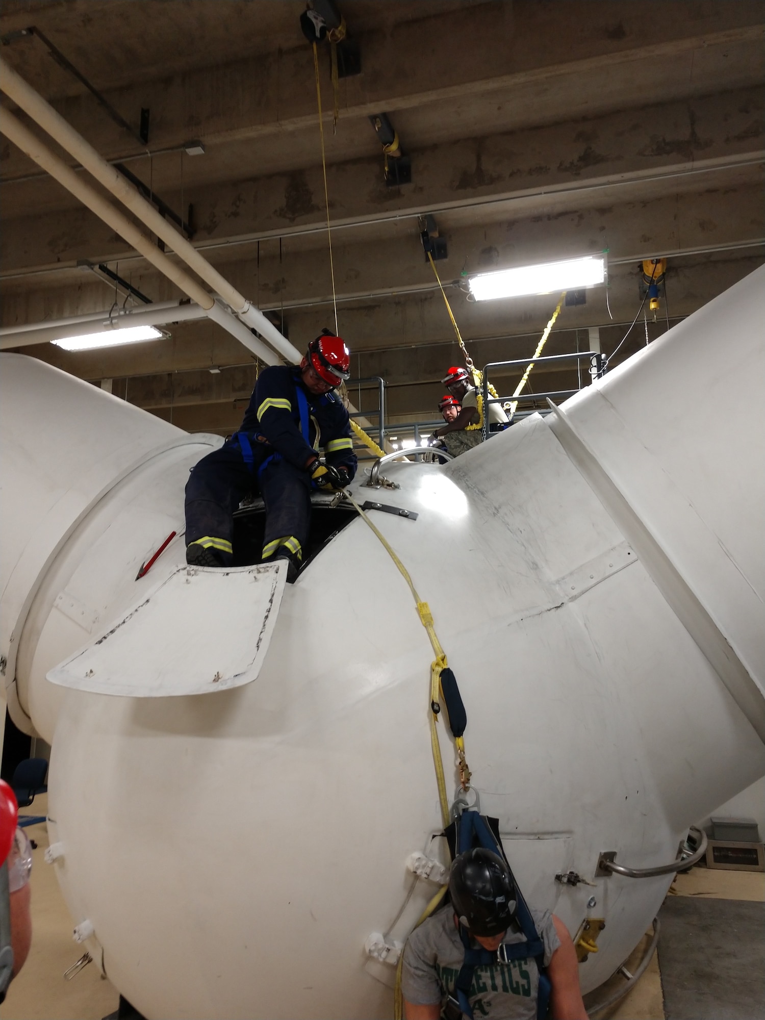 Cody Woolett, 90th Civil Engineer Squadron lead firefighter, preforms an over the hub rescue on a wind turbine at the Laramie County Community College Climb Safety Lab, Cheyenne, Wyo., June 5, 2018. The firefighters participating in the course learned and practiced different methods of recovery for each stage of the wind turbine. (Courtesy Photo)