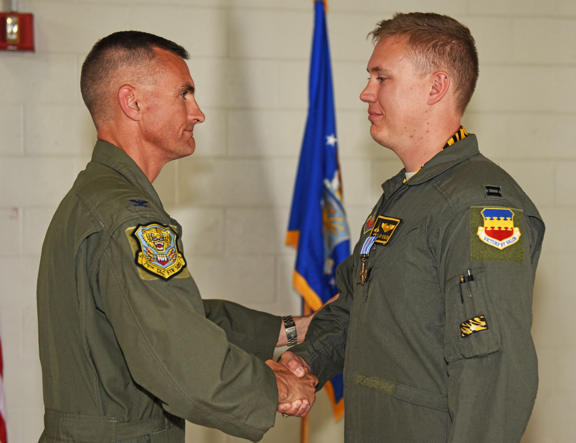 U.S. Air Force Col. Daniel Lasica, former 20th Fighter Wing commander, presents the Distinguished Flying Cross to Capt. John Nygard, 79th Fighter Squadron instructor pilot, at Shaw Air Force Base, S.C., June 7, 2018.