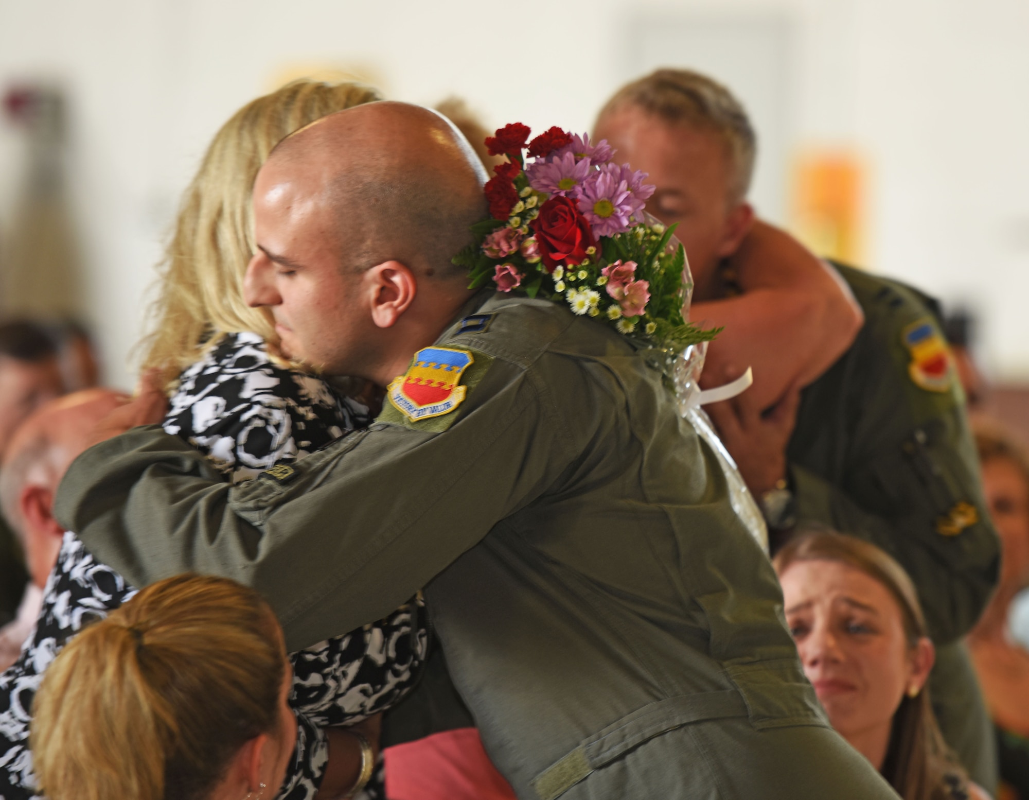 U.S. Air Force Captains John Nygard and Salvador Cruz, 79th Fighter Squadron instructor pilots, present flowers to friends and family members during a Distinguished Flying Cross presentation (DFC) ceremony at Shaw Air Force Base, S.C., June 7, 2018.
