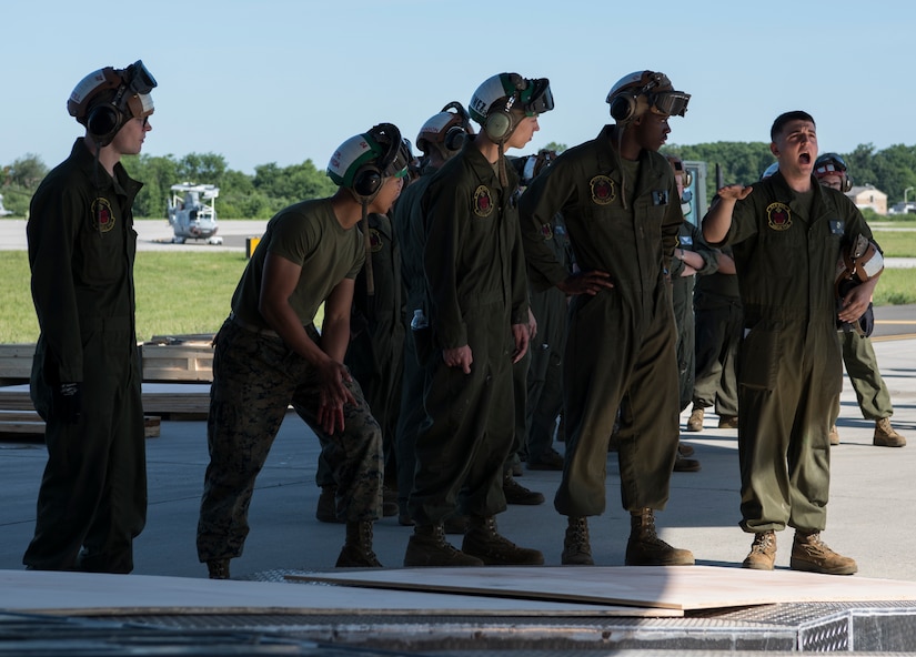U.S. Marine Corps Sgt. Michael Sailor, Marine Light Attack Helicopter Squadron 773 lead flightline mechanic, (right) directs Marines during the 2018 Marine Aircraft Group-49 Combined Arms Exercise on Joint Base McGuire-Dix-Lakehurst, N.J., June 12, 2018. The Marines loaded a U.S. Marine Corps aircraft AH-1 SuperCobra and CH-53 Sea Stallion onto a U.S. Air Force C-17 Globemaster III heading to New Orleans, kicking off the two-week large-scale joint training operation. (U.S. Air Force photo by Airman Ariel Owings)