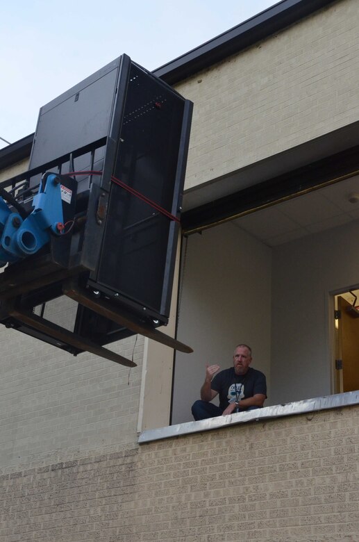 Mike Holt, a member of the Air Force Technical Applications Center's relocation team, guides a forklift hoisting information technology equipment onto the second floor of AFTAC's new contingency operations location at Naval Support Activity Mid-South.  Holt was one of several members of the nuclear treaty monitoring center who assisted with the relocation from San Antonio to Millington, Tenn.  (U.S. Air Force photo by Marvin T. Crumpton)