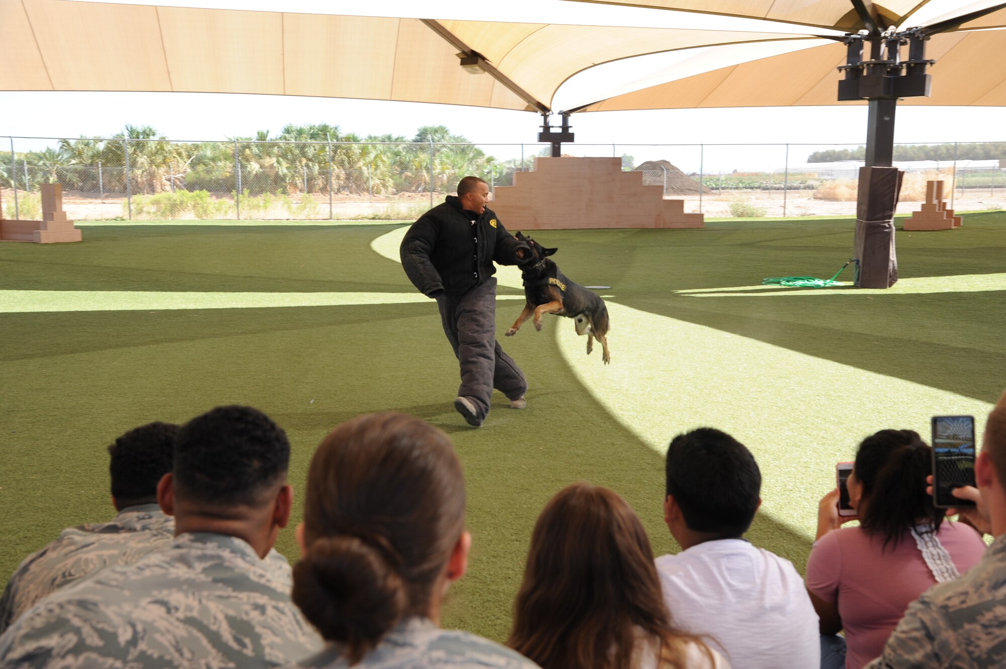 Staff Sgt. Jordan Cantrell, 56th Security Forces Squadron military working dog handler acts as a decoy during an exhibition at the 56th SFS Military Working Dog kennels at Luke Air Force Base, Ariz., June 12, 2018. The 56th SFS has partnered with Childhelp for the past 14 years through an annual Christmas toy and back-to-school supply drives. (U.S. Air Force photo by Tech. Sgt. Luther Mitchell)