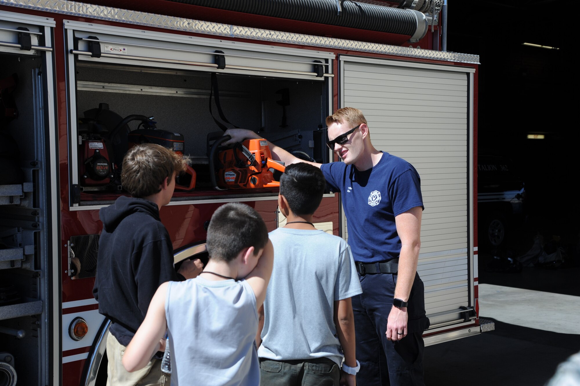 Ryan Witt, 56th Civil Engineer Squadron Fire and Emergency Services engineer, shows equipment on Engine 364 to the children of Childhelp at Luke Air Force Base, Ariz., June 12, 2018. Children spent time touring Fire Station 361’s living quarters, equipment and vehicles. (U.S. Air Force photo by Tech. Sgt. Luther Mitchell)