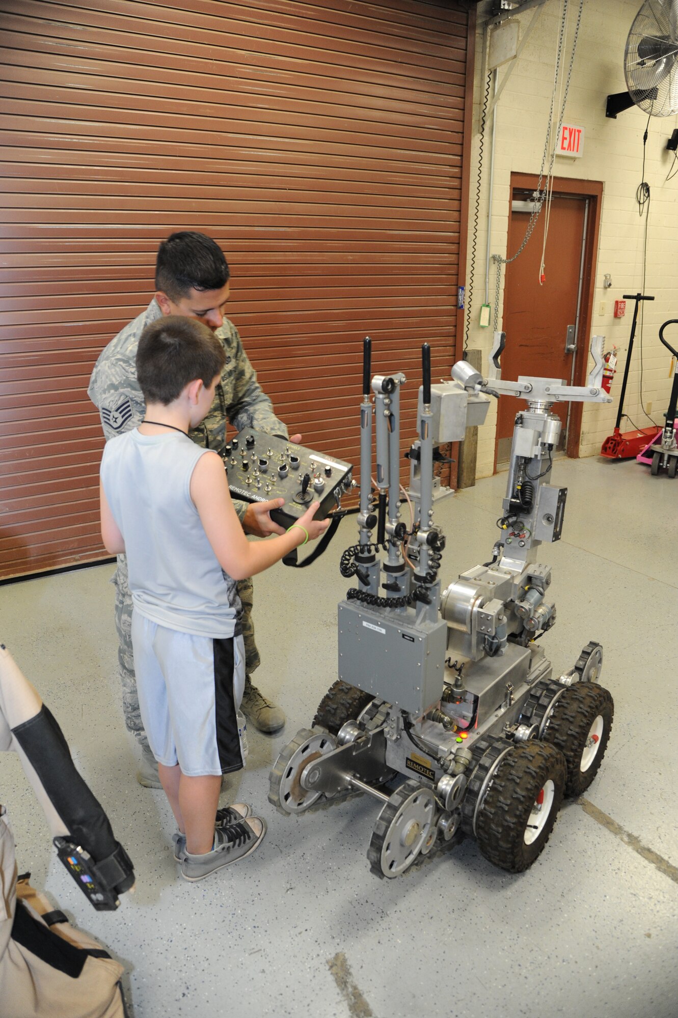 Staff Sgt. Raymond Johnson, 56th Civil Engineer Squadron Explosive Ordnance Disposal team leader, shows a child how to operate a base response tool at Luke Air Force Base, Ariz., June 12, 2018. The 56th Security Forces Squadron hopes to make “Day of Hope” an annual event with Childhelp. (U.S. Air Force photo by Tech. Sgt. Luther Mitchell)
