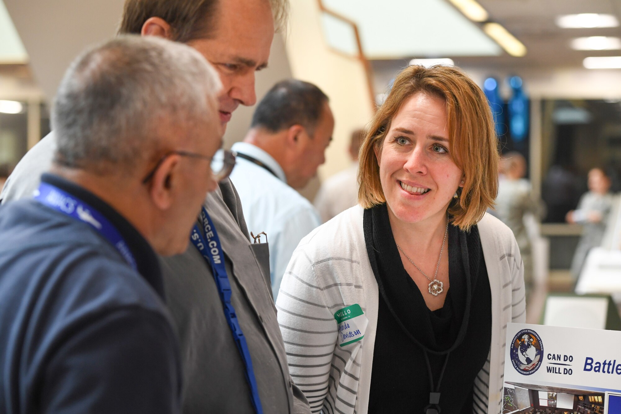 Amanda Davidson, right, supervisory financial specialist at the Aerospace Dominance Division at Hill Air Force Base, Utah, fields questions from visitors at the Battle Management Directorate financial management open house, June 13 at Hanscom Air Force Base, Mass. Davidson and a few of her coworkers set up a temporary duty trip in order to spread awareness of the test and training range support they provide, while also learning about other divisions reporting to the Battle Management Directorate at Hanscom. (U.S. Air Force Photo by Todd Maki)