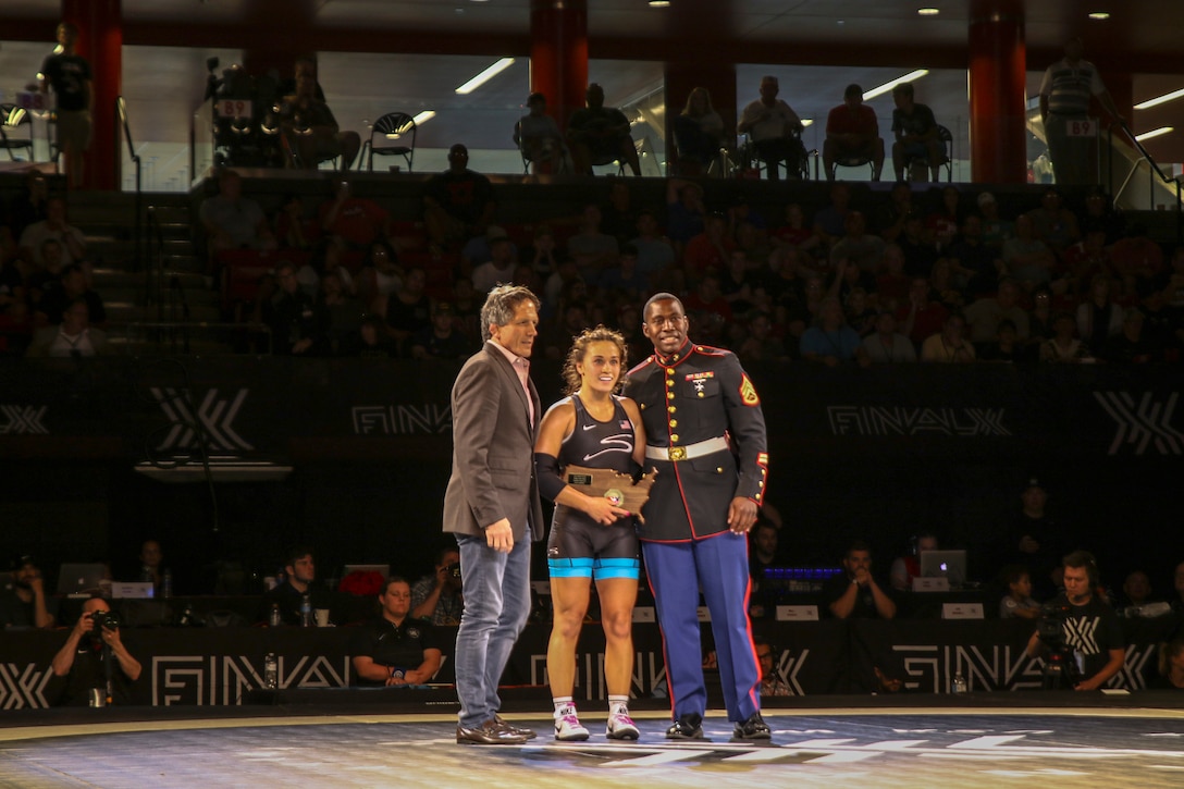 Staff Sgt. James Hunt, Officer Selection Assistant assigned to Officer Selection Office Lincoln, presents a plaque to Alli Ragan, Colorado Springs, Colo. native and world team member, at the FinalX Senior Freestyle World Team Trials at Bob Devaney Sports Center in Lincoln, Neb. June 9, 2018.