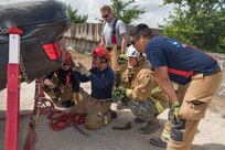 902nd Civil Engineer Squadron firefighters learn how to properly stabilize an overturned vehicle June 8, 2018, at Camp Talon, Joint Base San Antonio-Randolph. The firefighters took part in a three-day training course learning advanced techniques for vehicle extrication rescue. (U.S. Air Force photo by: Airman Shelby Pruitt.)