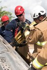 Jacob Mathie and Anthony Lira, 902nd Civil Engineer Squadron firefighters, use the Jaws of Life to pry open a door on an overturned car June 8, 2018, at Camp Talon, Joint Base San Antonio-Randolph. The members of the 902nd CES took a three-day course in which they learned new techniques for vehicle extrication and put them to practice. (U.S. Air Force photo by: Airman Shelby Pruitt.)