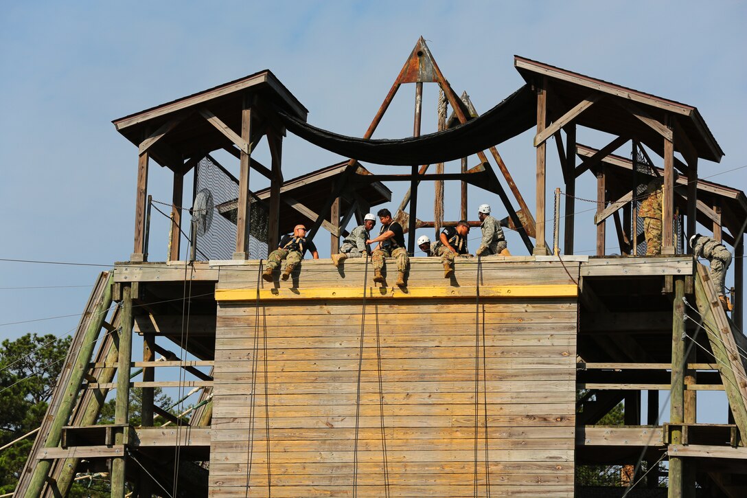 Cadets rappel down a tower during training.