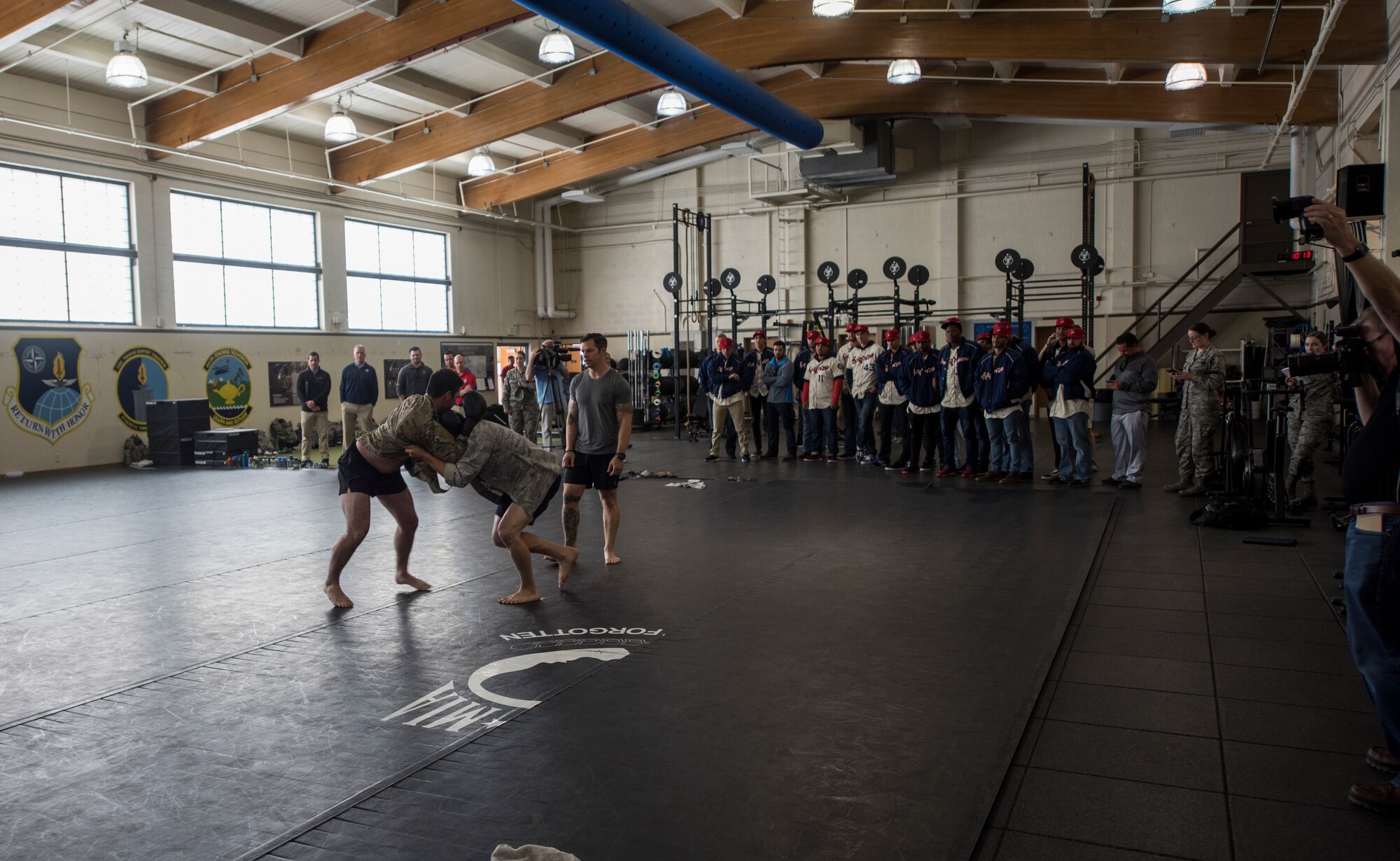 The Spokane Indians Baseball team observe a Survival, Evasion, Resistance and Escape hand-to-hand combat demonstration at Fairchild Air Force Base, Wash. June 12, 2018. The Air Force combatives program develops an Airman’s individual strength, confidence, resilience and lethality, while simultaneously imparting a strong warrior ethos. (U.S. Air Force photo/Senior Airman Sean Campbell)