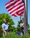 Charles Robert Johnson Jr. prepares to catch a 48-star flag lowered by Reserve Citizen Airman Maj. Scott D. Allen, 910th Airlift Wing chief of Public Affairs, June 14, here.