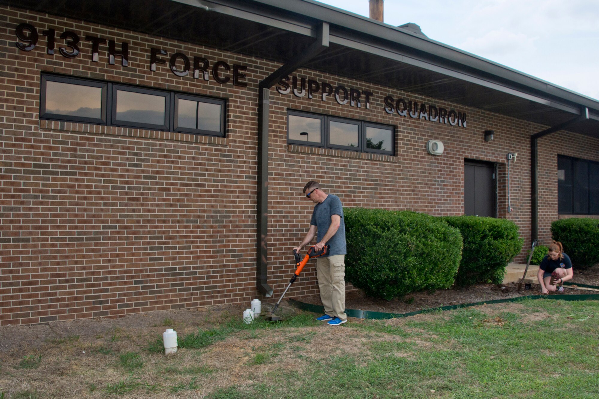 U.S. Air Force Reserve Tech Sgt. Malcolm Moe, historian for the 913th Airlift Group, and Senior Airman Tiah Phillips, knowledge management technician, 913th Force Support Squadron, giving some much needed TLC to flower beds outside of a 913th AG building, June 8, 2018, at Little Rock Air Force Base, Ark.
