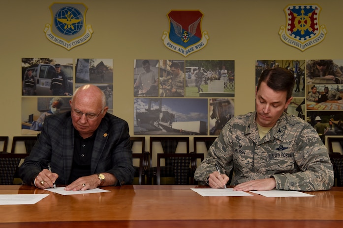 Col. Jeff Nelson, 628th Air Base Wing commander, right, and Paul Campbell Jr., executive director and CEO of the Aviation Authority, left, sign a memorandum of understanding for airfield snow and ice removal June 14, 2018. The memorandum establishes policies and procedures recommended by a joint task force for the cooperation and coordination of snow removal operations at the jointly used flying facilities.(U.S. Air Force photo by Senior Airman Tenley Long)