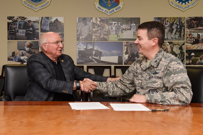 Col. Jeff Nelson, 628th Air Base Wing commander, right, and Paul Campbell JR., state of South Carolina senator, left, sign a memorandum of understanding for airfield snow and ice removal June 14, 2018. The memorandum establishes policies and procedures recommended by a joint task force for the cooperation and coordination of snow removal operations at the jointly used flying facilities.(U.S. Air Force photo by Senior Airman Tenley Long)