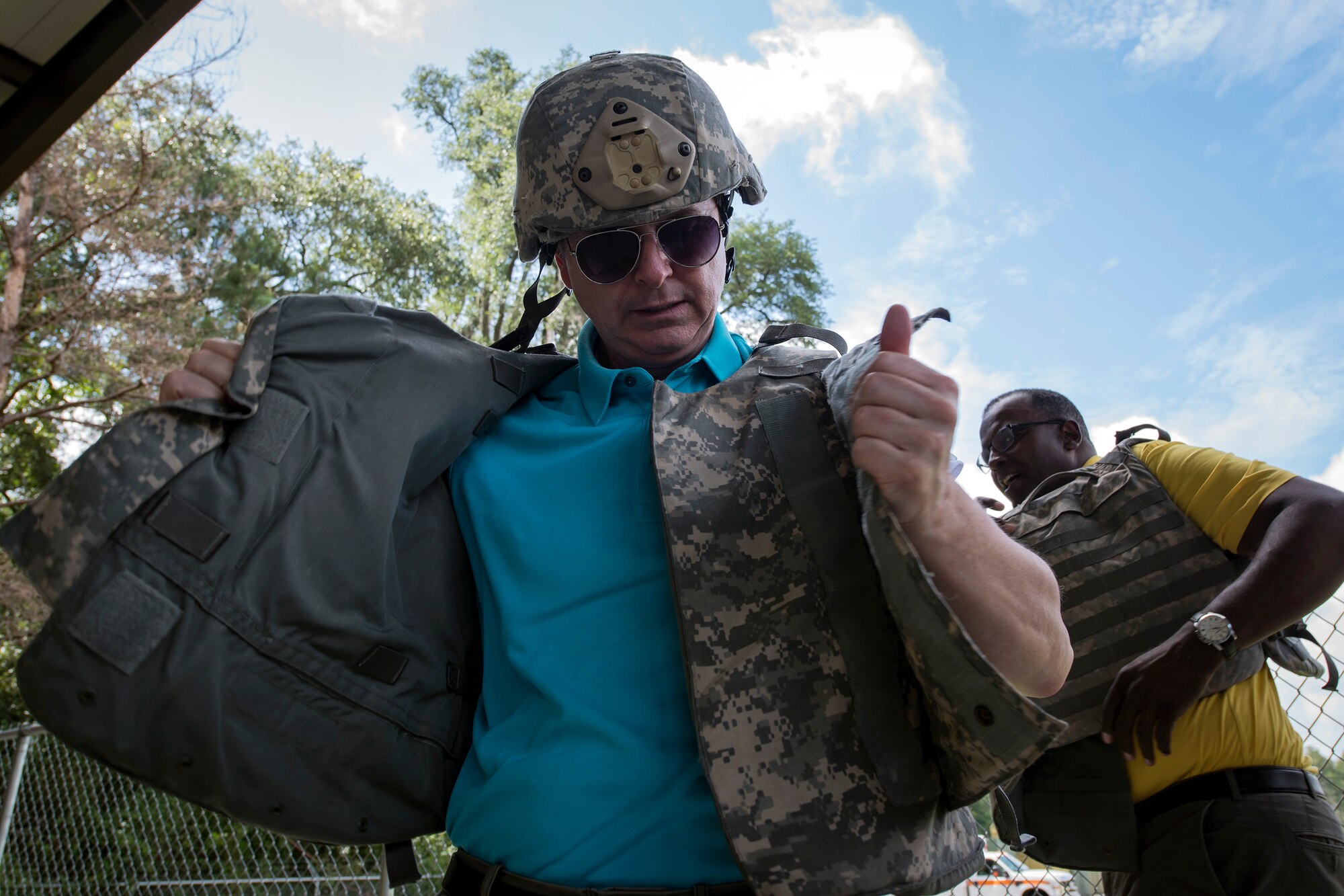 Tim Tynan, left, Joint Civilian Orientation Course (JCOC) 88 member, puts on a military vest, June 13, 2018, at Moody Air Force Base, Ga. The mission of JCOC is to increase the public’s understanding of the military through engagements between the armed forces and course members. (U.S. Air Force photo by Airman 1st Class Eugene Oliver)