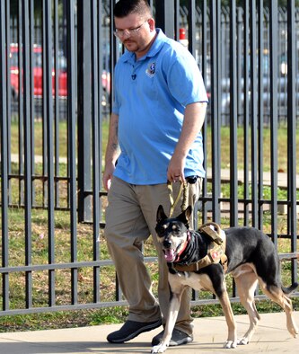 Ryan Kaono, a support agreement manager with the Air Force Installation and Mission Support Center, takes his service dog Romeo for a walk around his work center. Thanks to Romeo, Kaono is able to quickly transition through bouts of anxiety and night terrors. (U.S. Air Force photo by Armando Perez)