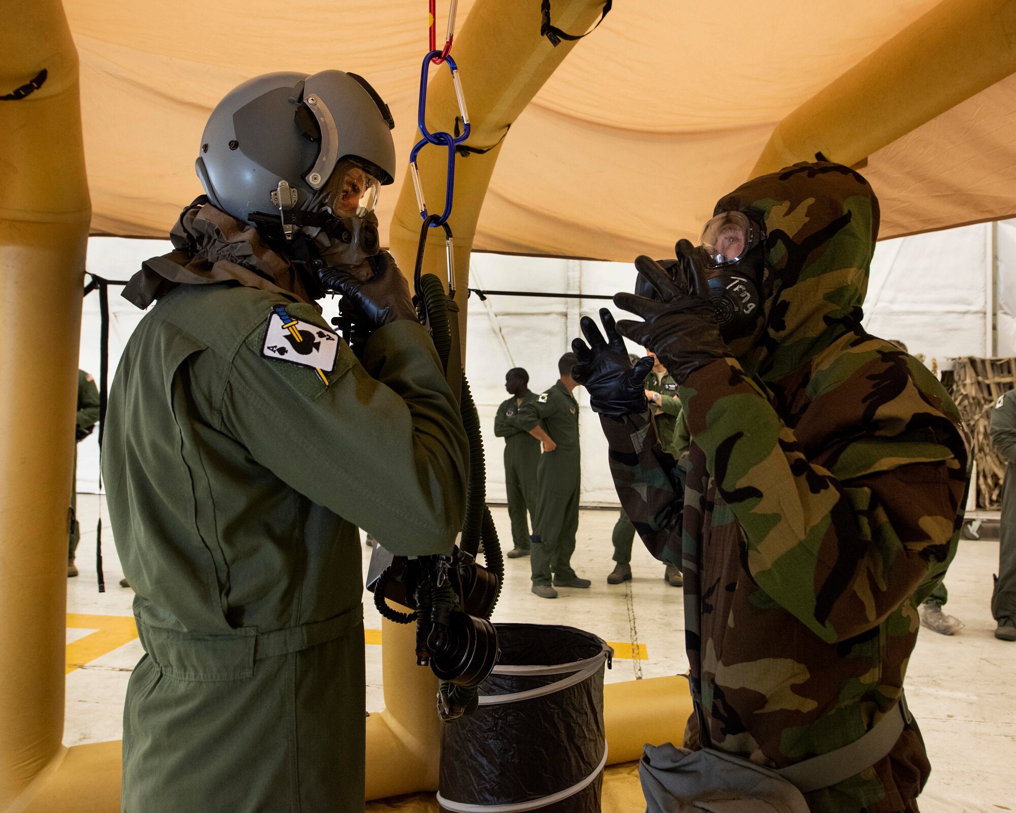 Senior Airman Jacob Stewart, an aircrew flight equipment technician with the 141st Operations Support Squadron, guides Tech. Sgt. Steve Kerr, a boom operator with the 116th Air Refueling Squadron, through the Aircrew Contamination Control Area June 7, 2018 at Fairchild Air Force Base, Wash. Guardsmen from the 141st OSS set up a mock ACCA line for training on the decontamination procedures involving aircrew members in response to a chemical, biological, radiological or nuclear attack. (U.S. Air National Guard photo by Staff Sgt. Rose M. Lust)