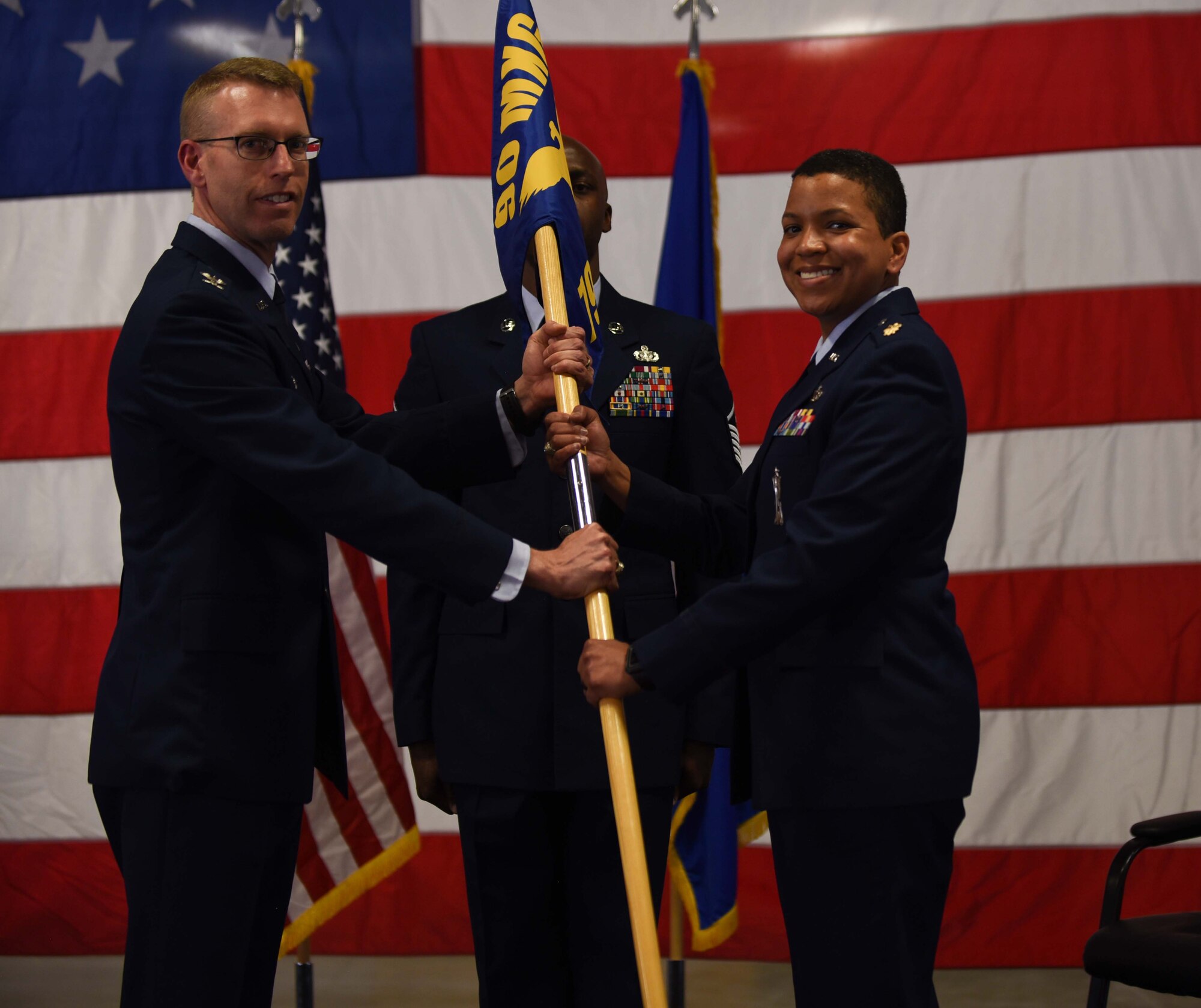 Col. Greg Buckner, 90th Maintenance Group commander, passes the guidon to Maj. Christine Hernandez, 790th Maintenance Squadron commander, during the 790th MXS change of command ceremony at F.E. Warren Air Force Base, Wyo., June 14, 2018. The ceremony signified the transition of command from Lt. Col. Grant Fowler. (U.S. Air Force photo by Airman 1st Class Abbigayle Wagner)