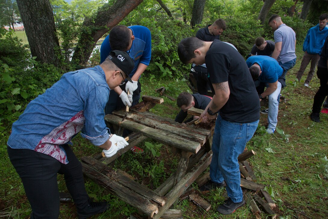 U.S. Marines with 3rd Battalion, 12th Marine Regiment, 3rd Marine Division, break down old benches during a community service event at the Chuo International Friendship Center May 9
