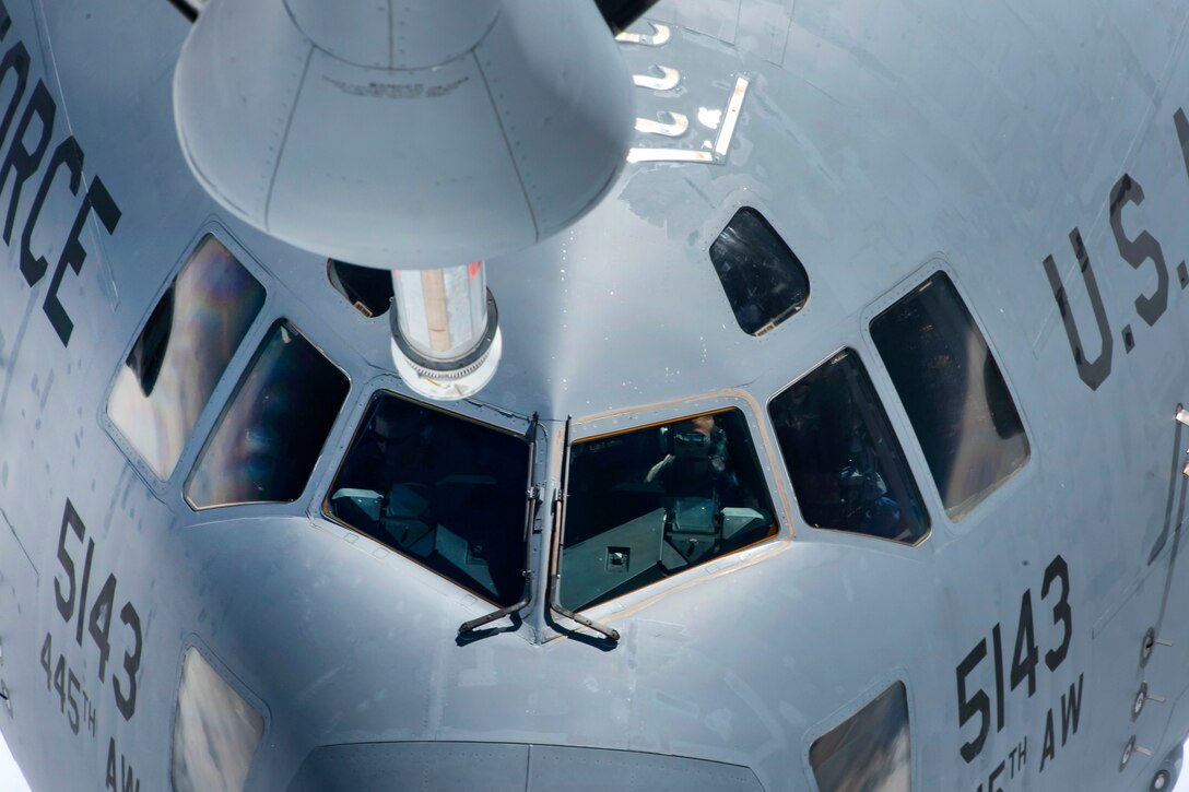 A C-17 Globemaster III flies toward a KC-135 Stratotanker aircraft.