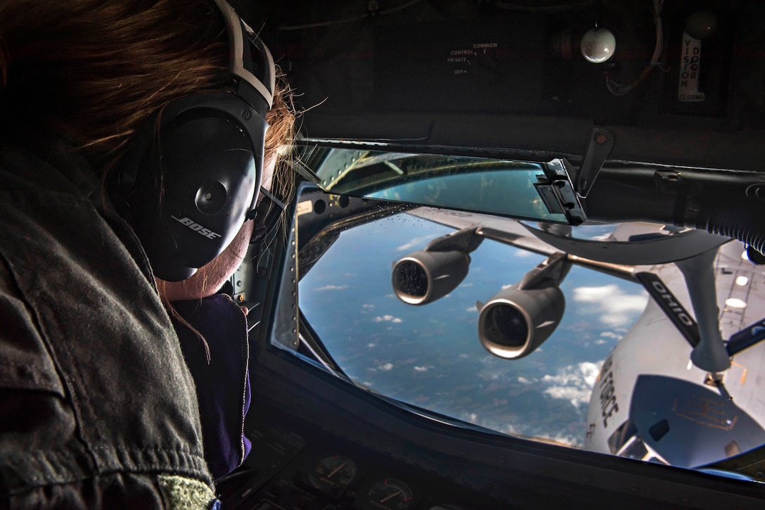 An airman operates the boom of a KC-135 Stratotanker aircraft.
