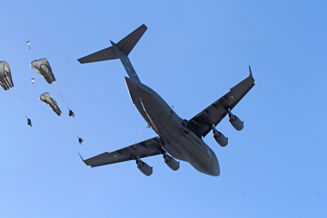 Soldiers jump from a C-17 Globemaster III aircraft during an airborne insertion exercise.