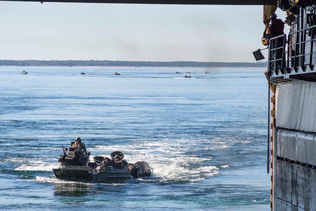 Marines maneuver their AAV-P7/A1 assault amphibious vehicle to enter  the well deck.