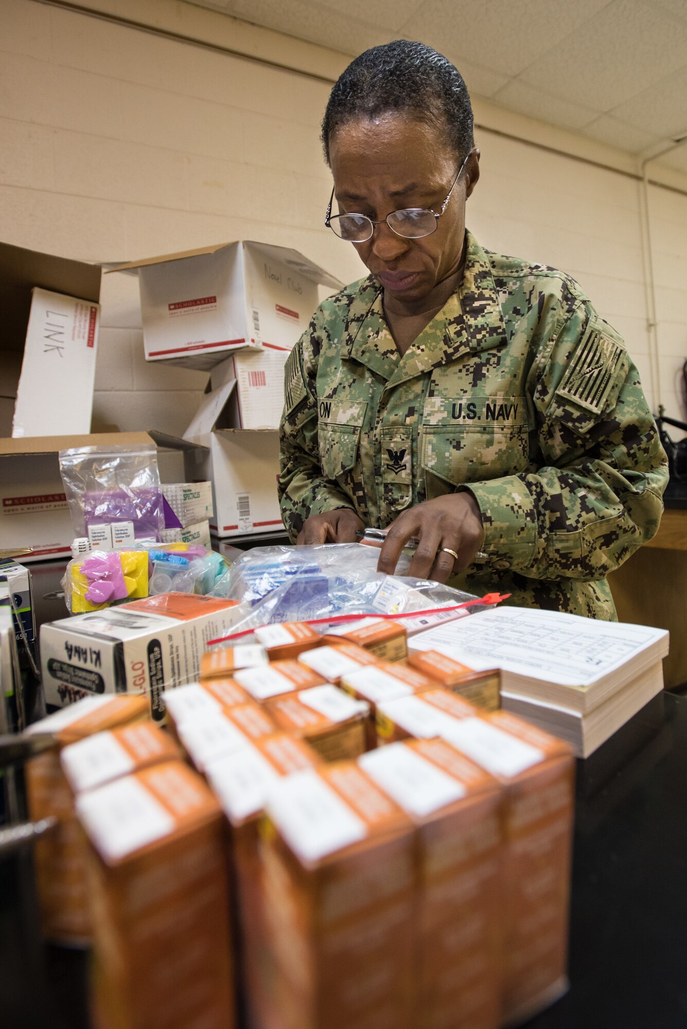 U.S. Navy HM2 Delphine On, a medical technician from Expeditionary Medical Facility Bethesda in Maryland, takes stock of medical supplies for a health-care clinic at Lee County High School in Beattyville, Ky., June 14, 2018. The clinic is one of four being staffed by military health-care professionals in Eastern Kentucky from June 15 to June 24 as part of an Innovative Readiness Training mission called Operation Bobcat. The mission provides military forces with crucial expeditionary training while offering no-cost medical, dental and optometry care to area residents. (U.S. Air National Guard photo by Lt. Col. Dale Greer)