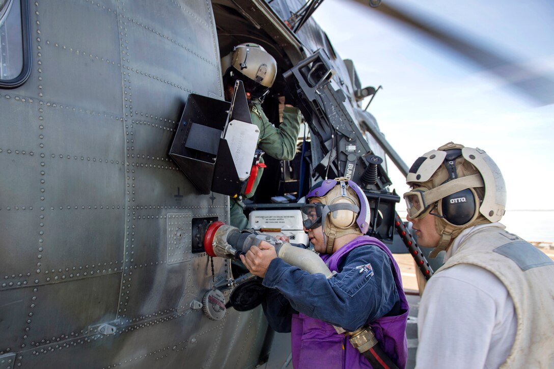 A sailor refuels a German Sikorsky S-61 helicopter.
