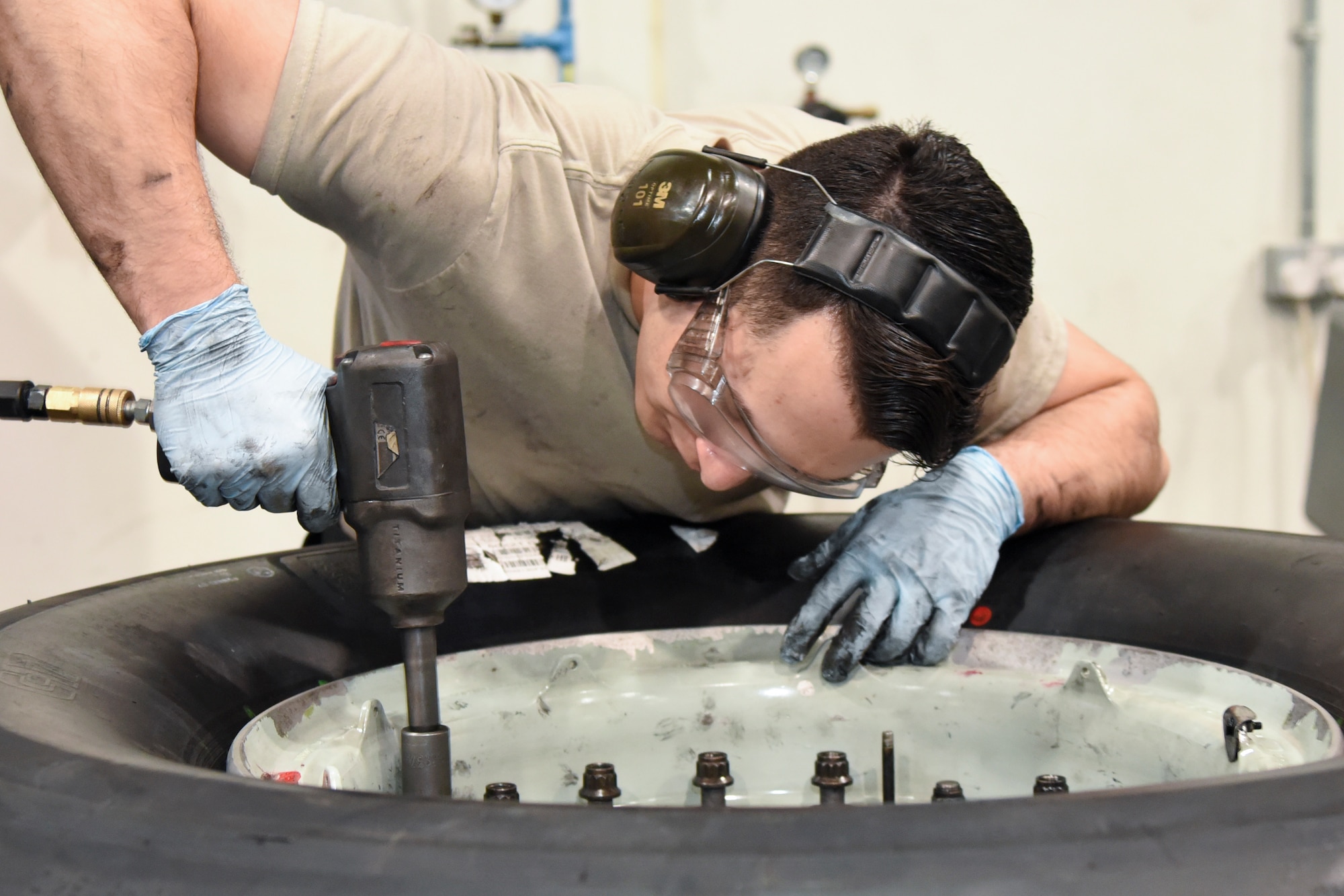 Airman 1st Class Christian Risenhoover, 379th Expeditionary Maintenance Squadron wheel and tire technician, removes bolts from a C-17 Globemaster III wheel assembly at Al Udeid Air Base, Qatar, June 13, 2018. The 379 EMXS supplies an average of 180 wheels a month to various deployed aircraft. (U.S. Air Force photo by Staff Sgt. Enjoli Saunders)