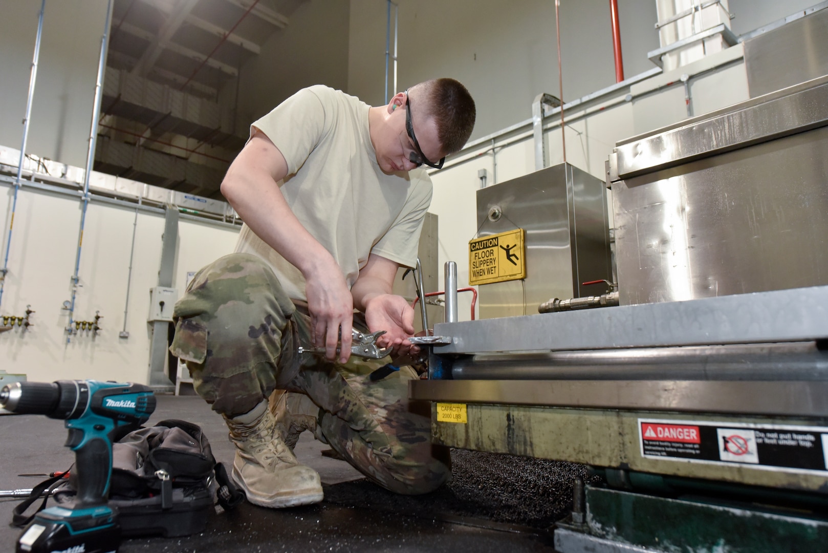 Senior Airman Justin Travis, 379th Expeditionary Maintenance Squadron metals technician, installs a bump stop on a washer grate at Al Udeid Air Base, Qatar, June 13, 2018. The bump stop serves as a mechanism to prevent the grate from extending past a certain point when servicing aircraft wheels. (U.S. Air Force photo by Staff Sgt. Enjoli Saunders)