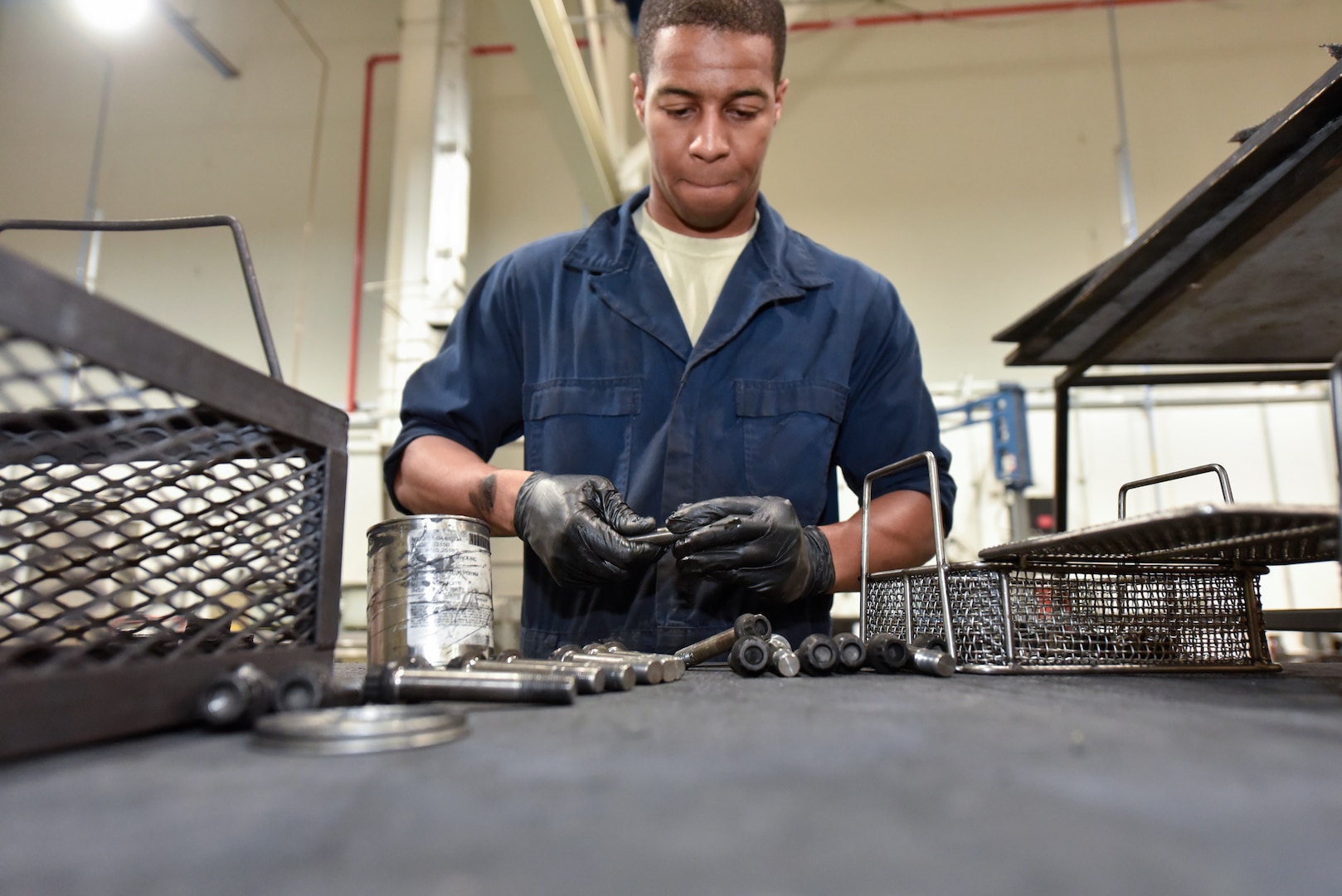 Senior Airman Jahlil Moses, 379th Expeditionary Maintenance Squadron wheel and tire technician, inspects bolts from a C-17 Globemaster III wheel assembly at Al Udeid Air Base, Qatar, June 13, 2018. The 379 EMXS supplies an average of 180 wheels a month to various deployed aircraft. (U.S. Air Force photo by Staff Sgt. Enjoli Saunders)