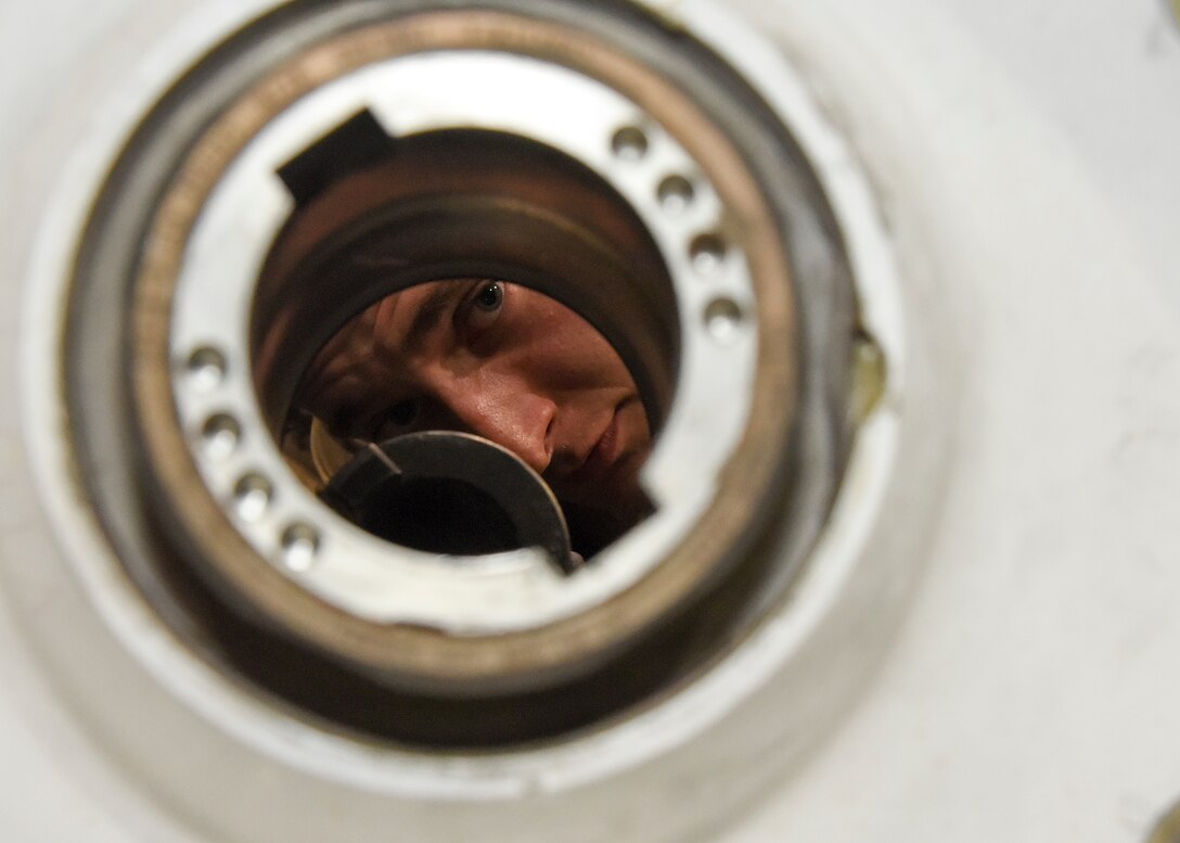 Airman 1st Class Loren Griffiths, 379th Expeditionary Maintenance Squadron wheel and tire technician, peers through the core of C-17 Globemaster III wheel assembly at Al Udeid Air Base, Qatar, June 6, 2018. The 379th EMXS supplies an average of 180 wheels a month to various deployed aircraft. (U.S. Air Force photo by Staff Sgt. Enjoli Saunders)