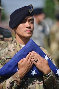 U.S. Air Force Senior Airman Yanny Nguyen, a defender assigned to the 509th Security Forces Squadron, holds the U.S. flag during a flag folding ceremony in remembrance of the six fallen Airmen of Charlie Fire Team at Whiteman Air Force Base, Missouri, June 10, 2018