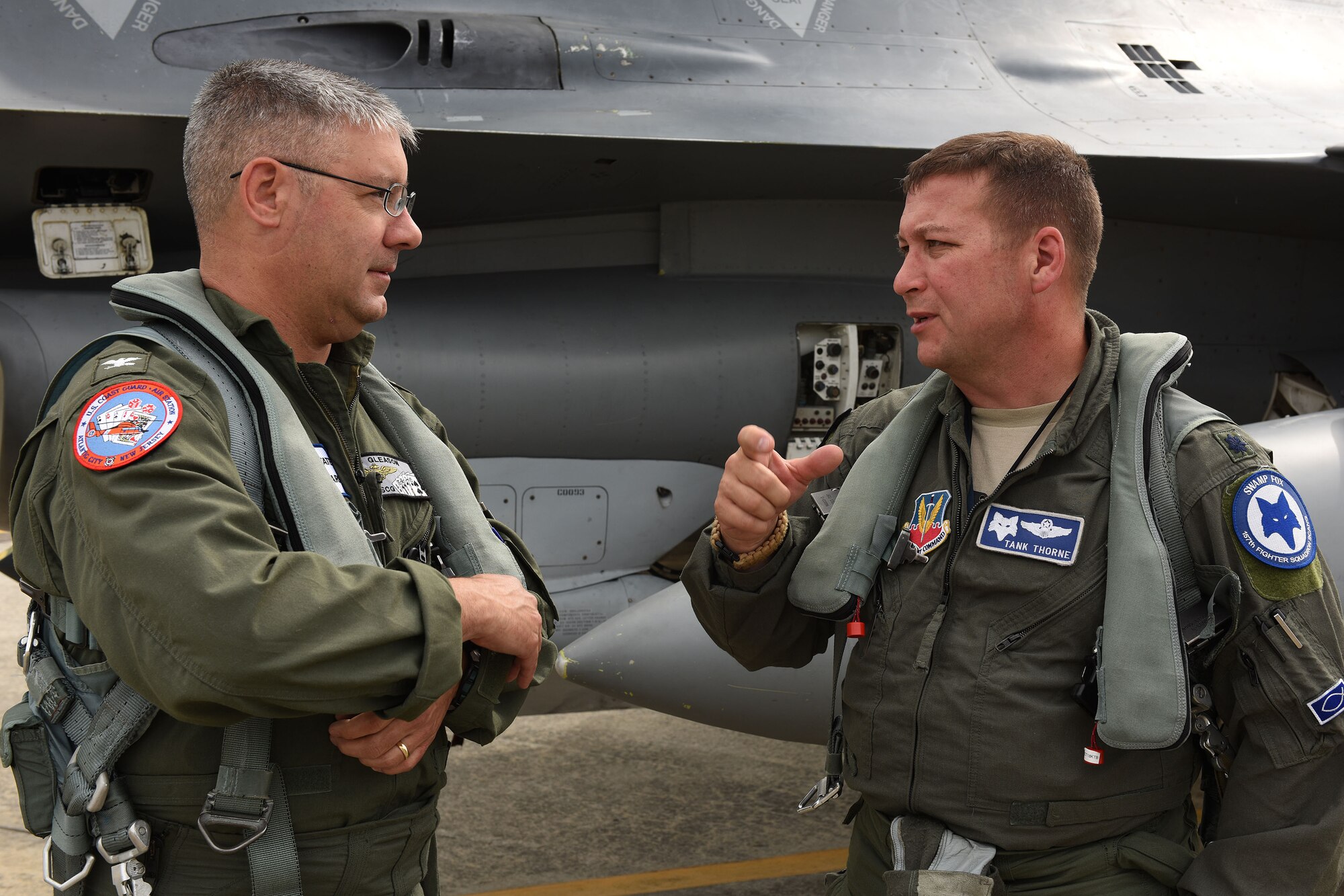 U.S. Coast Guard Capt. Eric Gleason, assigned to USCG Air Station Atlantic City, talks with Lt. Col. Andrew Thorne, 169th Fighter Wing, South Carolina Air National Guard, following an Aerospace Control Alert familiarization flight in an F-16 Fighting Falcon during the Southeast ACA Conference June 5. The 169th Fighter Wing, in close coordination with the Continental U.S. North American Aerospace Defense Command Region, the Eastern Air Defense Sector and the Federal Aviation Administration, hosted the Southeast Aerospace Control Alert Conference at McEntire Joint National Guard Base, S.C., June 5-7. The conference was a total-team training initiative to improve homeland defense capabilities by developing techniques with joint forces during small-scale exercises. This conference consisted of South Carolina Air National Guard 169th FW F-16 fighter jets, U.S. Coast Guard Rotary Wing Air Intercept Squadron MH-65D Dolphin helicopters from USCG Air Station Atlantic City and South Carolina Wing Civil Air Patrol aircraft and crews to hone their skills with tactical-level air-intercept procedures. (U.S. Air National Guard photo by Senior Master Sgt. Edward Snyder)