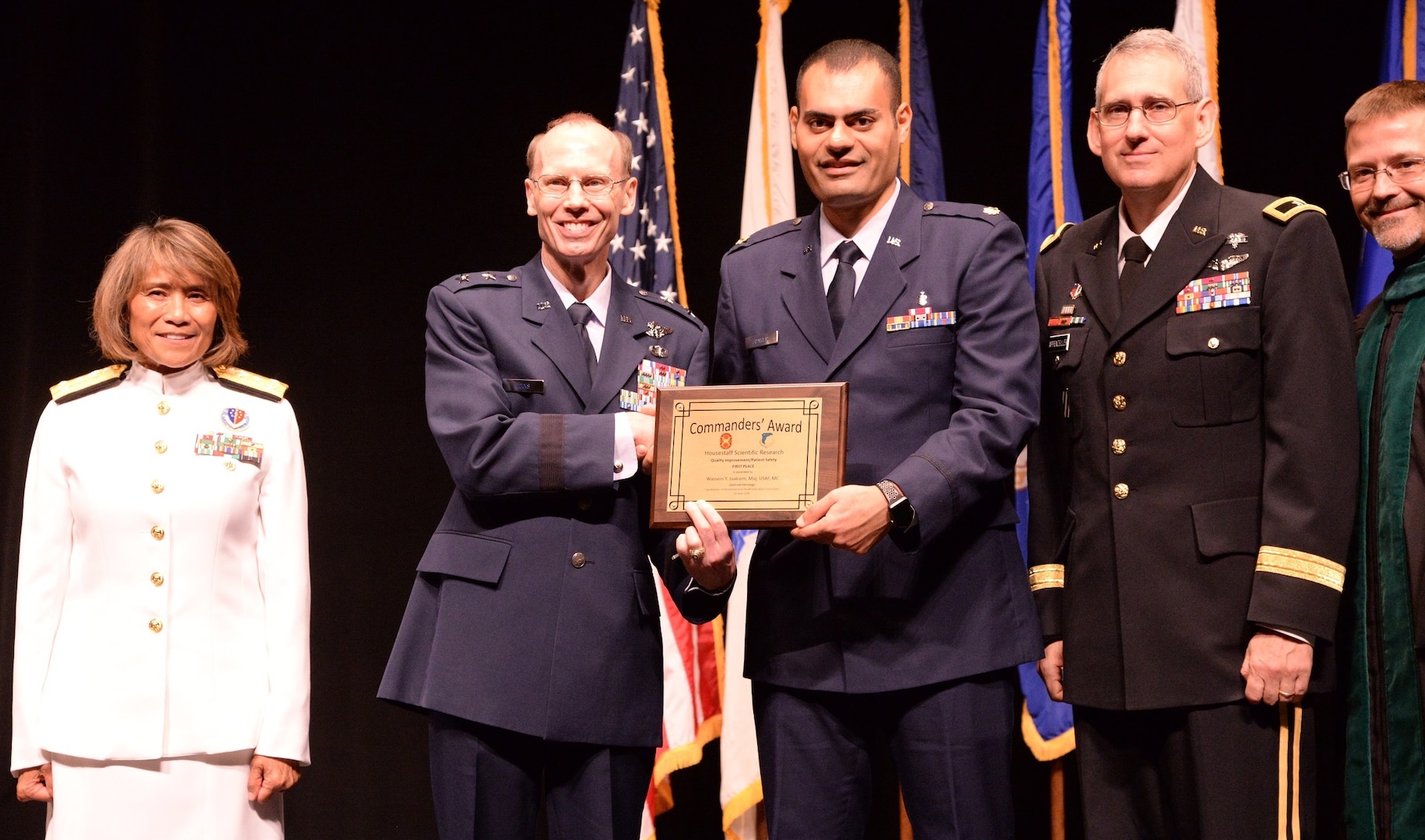Air Force Maj. Wassem Juakiem, gastroenterology fellow, receives the Commander’s Award for Quality Improvement and Patient Safety during the San Antonio Uniformed Services Health Education Consortium graduation ceremony held June 7 at the Lila Cockrell Theatre in downtown San Antonio. Also pictured are (from left) Vice Adm. Raquel Bono, director of the Defense Health Agency; Air Force Maj. Gen. Bart O. Iddins, 59th Medical Wing commander; Army Brig. Gen. George Appenzeller, Brooke Army Medical Center commander; and Dr. Woodson Scott Jones, dean of SAUSHEC.