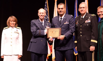 Air Force Maj. Wassem Juakiem, gastroenterology fellow, receives the Commander’s Award for Quality Improvement and Patient Safety during the San Antonio Uniformed Services Health Education Consortium graduation ceremony held June 7 at the Lila Cockrell Theatre in downtown San Antonio. Also pictured are (from left) Vice Adm. Raquel Bono, director of the Defense Health Agency; Air Force Maj. Gen. Bart O. Iddins, 59th Medical Wing commander; Army Brig. Gen. George Appenzeller, Brooke Army Medical Center commander; and Dr. Woodson Scott Jones, dean of SAUSHEC.